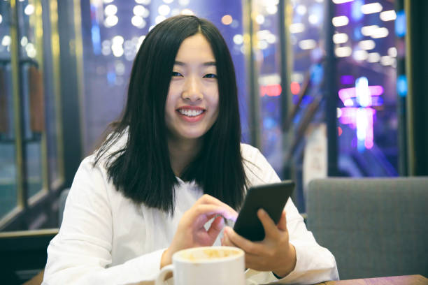 portret van lachende meisje met telefoon in café - happy friday emoticon stockfoto's en -beelden