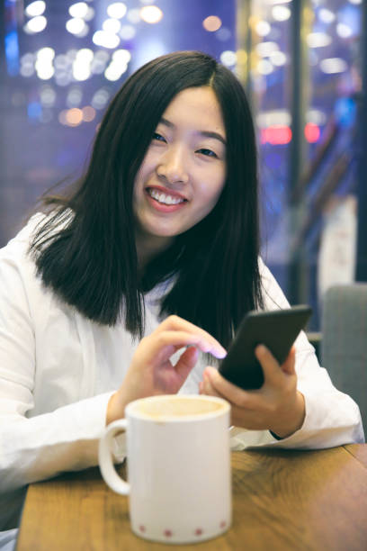 portret van lachende meisje met telefoon in café - happy friday emoticon stockfoto's en -beelden
