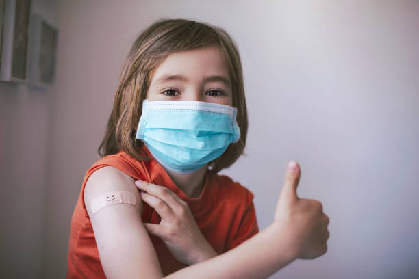 Portrait of smiling little child with adhesive bandage on his hand after vaccination stock photo
