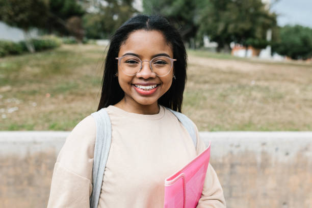 Portrait of smiling young hispanic latina student at campus school university stock photo