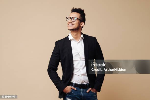 Portrait of successful black businessman standing against beige background