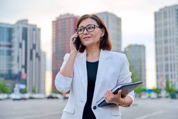 Portrait of successful mature businesswoman with smartphone outdoor stock photo