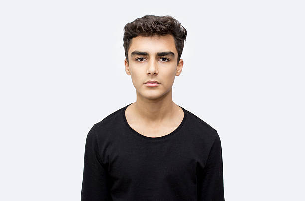 Portrait of teenage boy over white background stock photo