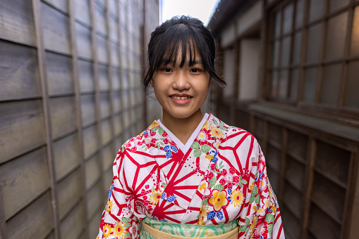 Teenage girl visiting traditional Japanese village Sawara, UNESCO World Heritage Site. Wearing Kimono and walking around the village.