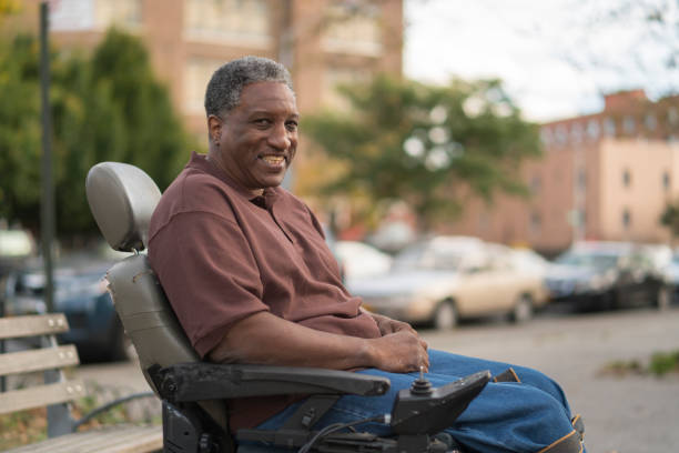 portrait of the positive, optimistic disabled black man, paralized veteran who sitting in wheelchair - wheelchair street happy imagens e fotografias de stock
