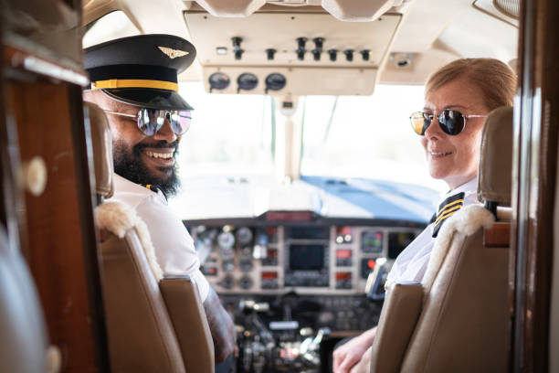 Portrait of two airplane pilots looking over shoulder in a private jet Portrait of two airplane pilots looking over shoulder in a private jet pilot stock pictures, royalty-free photos & images