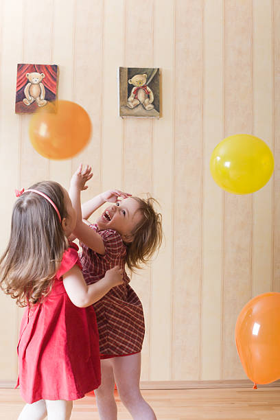 Portrait of two little girls playing with airy balls stock photo