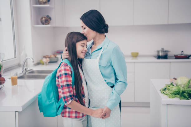 portrait of two nice-looking cute winsome lovely sweet attractive cheerful people mature kind careful mum holding hands kissing in light white kitchen interior indoors - foster home bag imagens e fotografias de stock