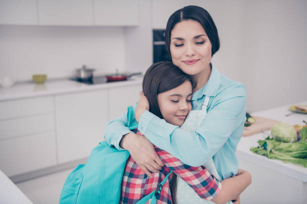 portrait of two nice-looking cute winsome lovely sweet charming attractive dreamy peaceful people mature mommy cuddling spending time in light white kitchen interior indoors - foster home bag imagens e fotografias de stock