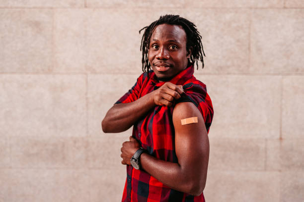 Portrait Of Vaccinated African Man Showing His Arm stock photo