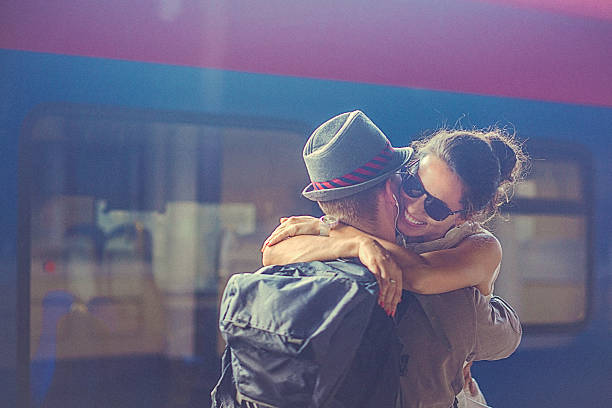 Portrait of woman and man embracing at the railway platform stock photo