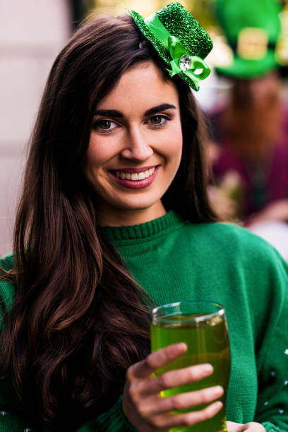 Portrait of woman celebrating St Patricks day Portrait of woman celebrating St Patricks day with a green pint irish women stock pictures, royalty-free photos & images