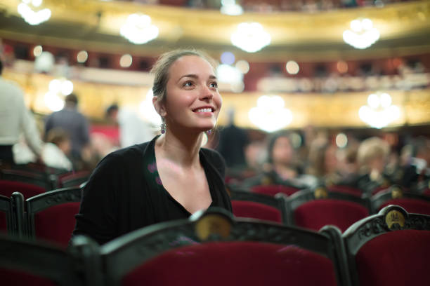 Portrait of woman in auditorium of theatre Portrait of excited young woman in auditorium of theatre classical style stock pictures, royalty-free photos & images