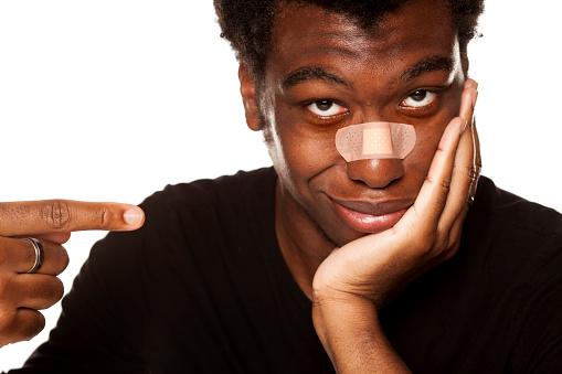 ✓ Imagen de Retrato de joven afroamericano con cinta venda sobre su nariz  sobre fondo blanco Fotografía de Stock