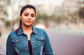 istock Portrait of young brunette Asian/ Indian girl wearing blue denim shirt 1321849541