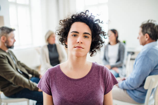 A portrait of young depressed woman during group therapy. A portrait of young attractive depressed woman during group therapy. drug rehab stock pictures, royalty-free photos & images