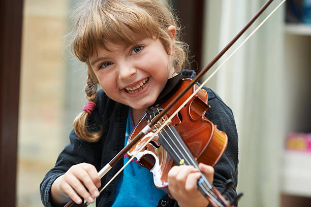 porträt von jungen mädchen lernen zu spielen violine - geige stock-fotos und bilder