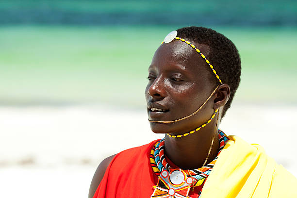 Portrait of young man as Massai warior Commercial portrait of young tribal Masai warrior man on hot bright sunny African beach maasai warrior stock pictures, royalty-free photos & images