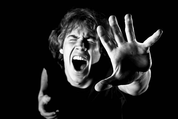 Portrait of Young Man Yelling Reaching Up, Black and White stock photo