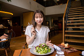 レストランで昼食にサラダを食べる若い女性の肖像画