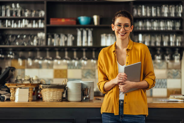Portrait of young woman holding tablet at cafe stock photo