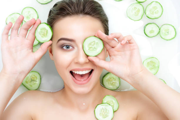 Portrait of young woman relaxing in white spa bath Portrait of sexy beauty Caucasian female woman with clean pure skin taking spa relaxing in bath with cucumber slices white soap shampoo water. Skin beauty health care concept. Body part bare shoulder cucumber stock pictures, royalty-free photos & images
