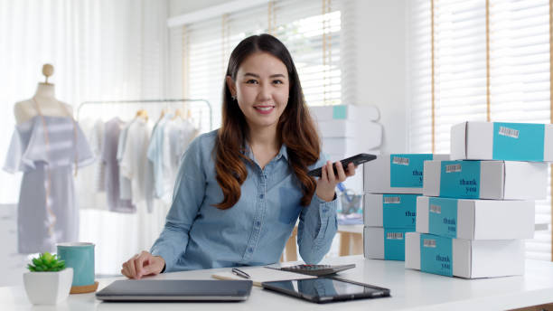 Portrait young attractive asia female owner startup business look at camera work happy with box at home prepare parcel delivery in sme supply chain, procurement, omnichannel commerce online concept. stock photo