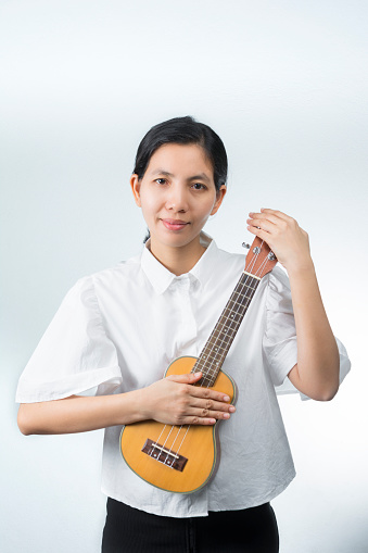 portraits Female Musician who embraces his favorite musical instruments cherish on white background.
