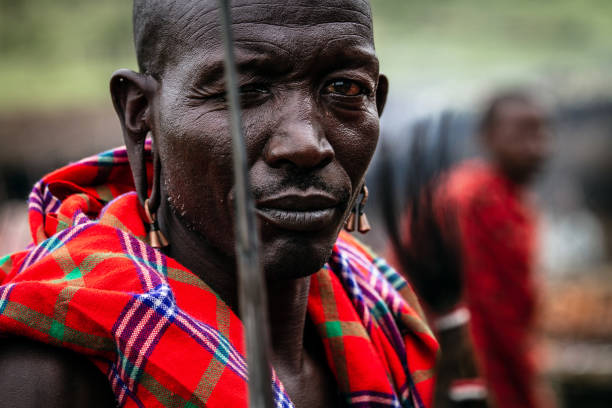 Portraits of the inhabitants of the Maasai village. Maasai Mara, Kenya - Desember 10, 2010 : Portrait of Maasai warrior dressed in his traditional clothes. The Masai people are a Nilotic ethnic group of semi-nomadic people located in Kenya and Tanzania. maasai warrior stock pictures, royalty-free photos & images