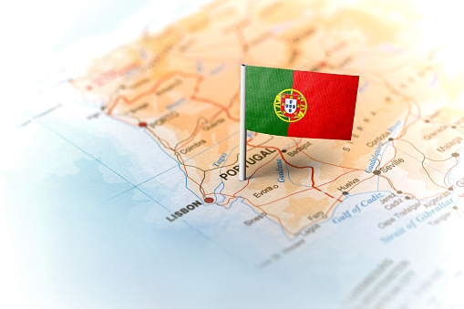 The flag of Portugal pinned on the map. Horizontal orientation. Macro photography.