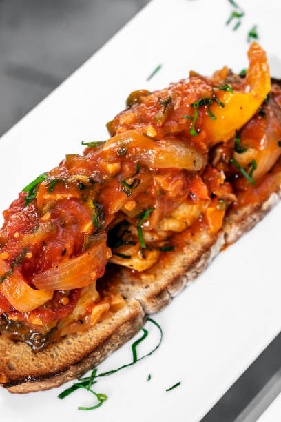 portuguese caldeirada de peixe spicy tomato onion and peppers fish stew on rustic tiborna toast tapas style portuguese caldeirada de peixe spicy tomato onion and peppers fish stew on rustic tiborna toast tapas style Selección de Portugal stock pictures, royalty-free photos & images