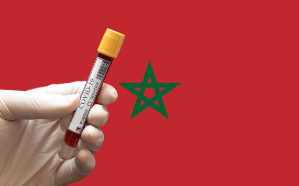 Positive COVID-19 blood test tube with Flag of Morocco at background. stock photo