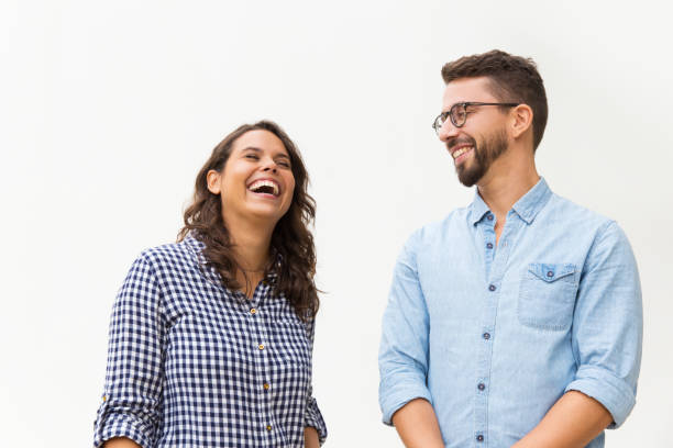 Positive funny guy making his girlfriend laugh stock photo