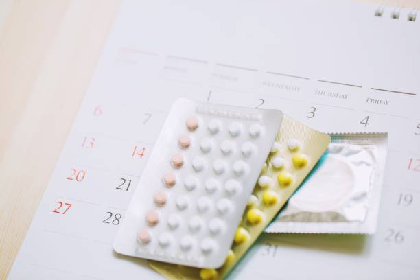 positive pregnancy test and contraceptive control pills on date of calendar background. health care and medicine Birth control concept.  contraceptive stock pictures, royalty-free photos & images