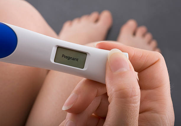 Positive result of pregnancy test Woman taking a pregnancy test showing pregnant result positive pregnancy test stock pictures, royalty-free photos & images