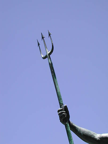 Posseidon's trident Part of a statue with an arm holding a trident with blue sky in the background trident spear stock pictures, royalty-free photos & images