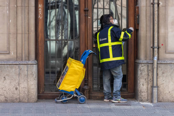Post delivery during Coronavirus Lockdown Barcelona Spain Barcelona, Spain. 8th April, 2020. Postman delivering mail during the state of alert due to Covid in Spain. Post delivery is considered an essential activity correspondence stock pictures, royalty-free photos & images