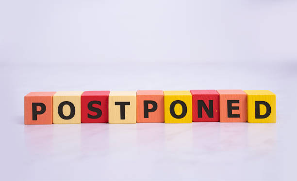Postponed - words from wooden blocks with letters, postponed concept, top view background. Postponed - words from wooden blocks with letters, postponed concept, top view background postponed stock pictures, royalty-free photos & images