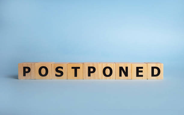 Postponed - words from wooden blocks with letters, postponed concept, top view background Postponed - words from wooden blocks with letters, postponed concept, top view background. postponed stock pictures, royalty-free photos & images