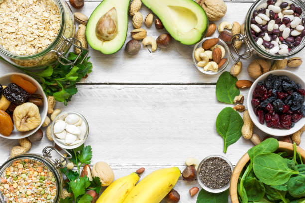 Potassium Food Sources . top view with copy space. flat lay Potassium Food Sources as dried apricots, raisins, avocado, bean, pumpkin and chia seeds, banana, nuts, spinach, hazelnuts, almonds. top view with copy space. flat lay potassium stock pictures, royalty-free photos & images