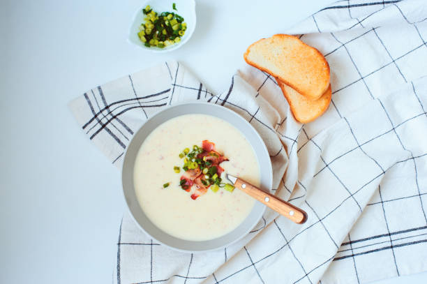 potato cream soup with bacon and green onion served in bowl on white background. Delicious food for winter lunch stock photo