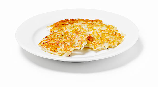 Potato pancakes in a dish on a white background Potato Pancakes (Latkas)   -Photographed on Hasselblad H1-22mb Camera hash brown photos stock pictures, royalty-free photos & images