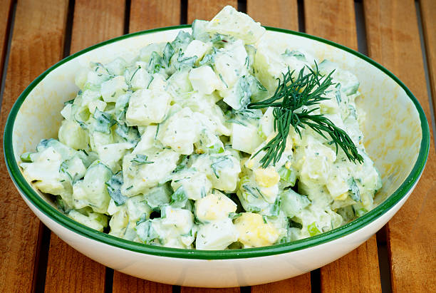 Potato Salad Delicious Freshly Made Creamy Potato Salad Garnished with Dill in Beige Bowl closeup on Wooden Plank background dill stock pictures, royalty-free photos & images