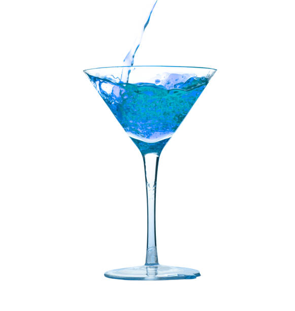 Pouring blue liquid drink into cocktail martini glass stock photo