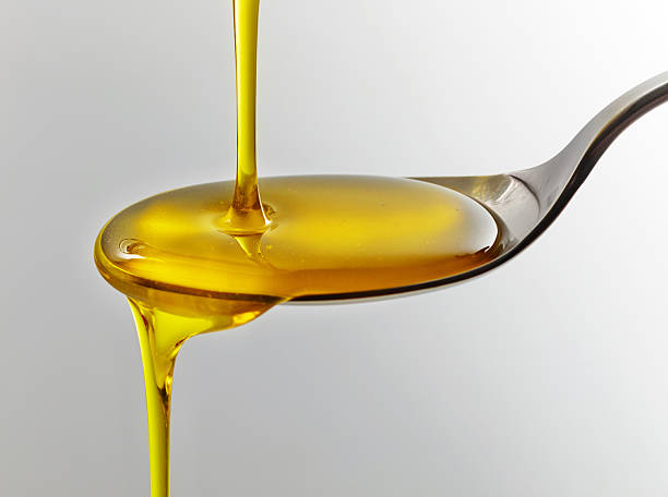 pouring cooking oil cooking oil pouring into spoon fish oil stock pictures, royalty-free photos & images
