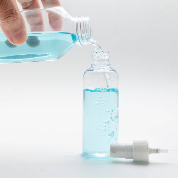 pouring disinfectant alcohol into a spray bottle. stock photo