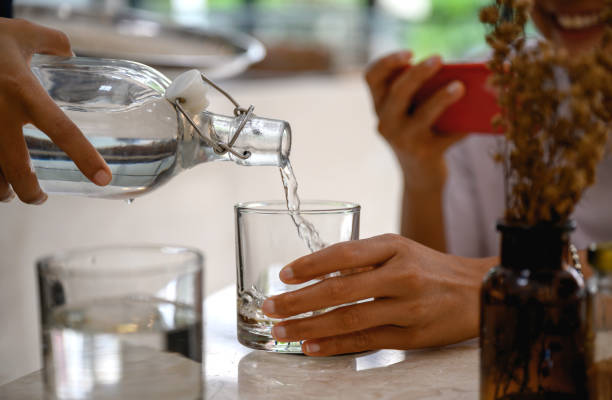 Pouring fresh cold water into a drinking glass stock photo