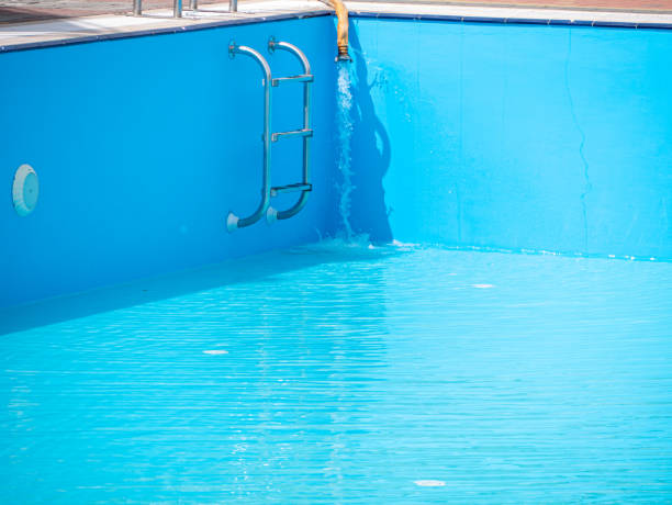 pouring fresh water into swimming pool. clear blue water refreshing disinfection purification, algae bacteria prevent. - zwembad vullen achtertuin stockfoto's en -beelden