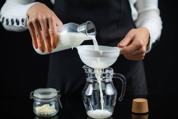 Pouring Milk Through a Stainer with Kefir Grains. Making Kefir at Home. Pouring milk through a stainer with kefir grains. Making kefir at home. kefir stock pictures, royalty-free photos & images