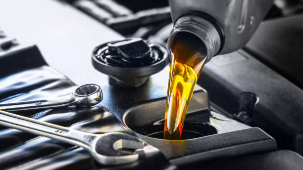 Pouring motor oil for motor vehicles from a gray bottle into the engine stock photo